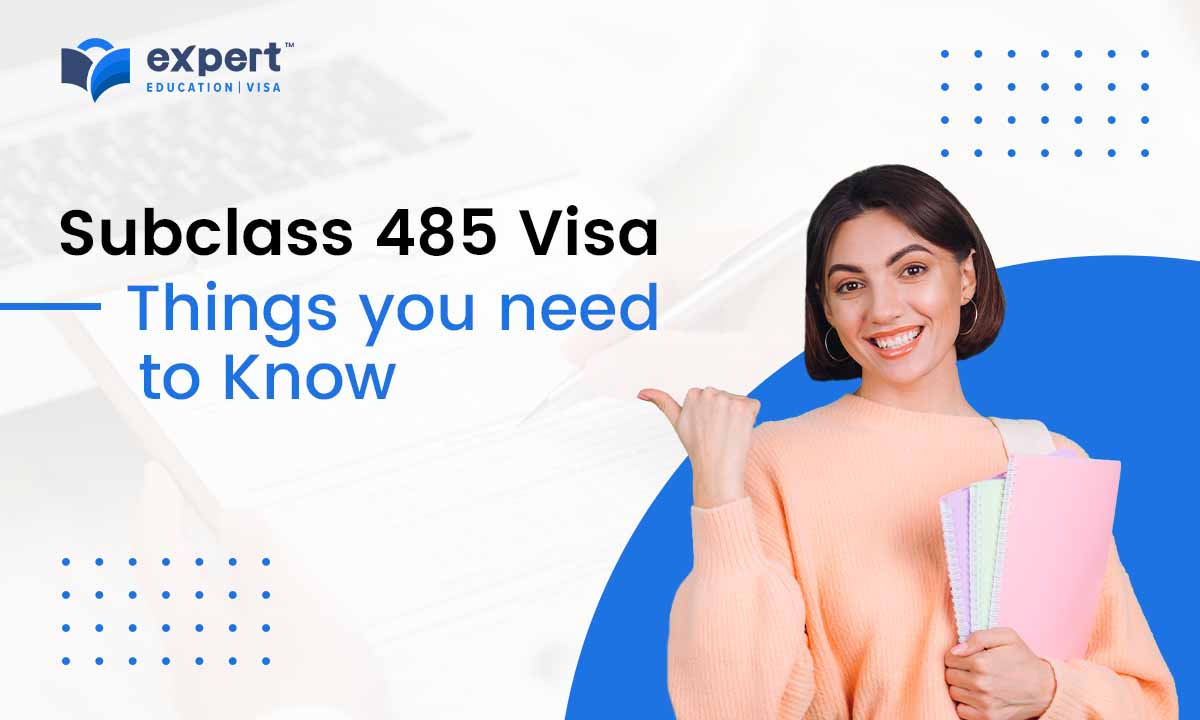 Smiling young student holding books and pointing to the 485 visa 